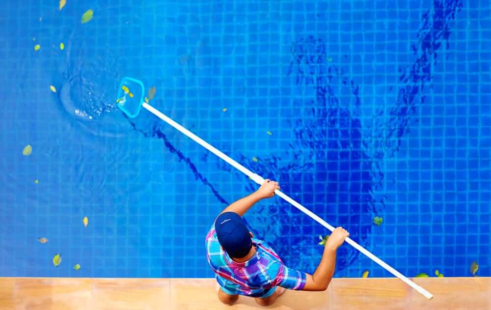 Birdseye view of man cleaning pool
