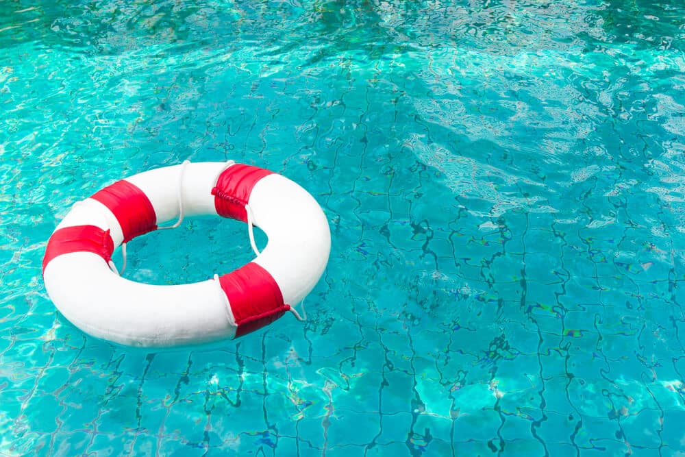 Life Ring on blue water at the swimming pool.