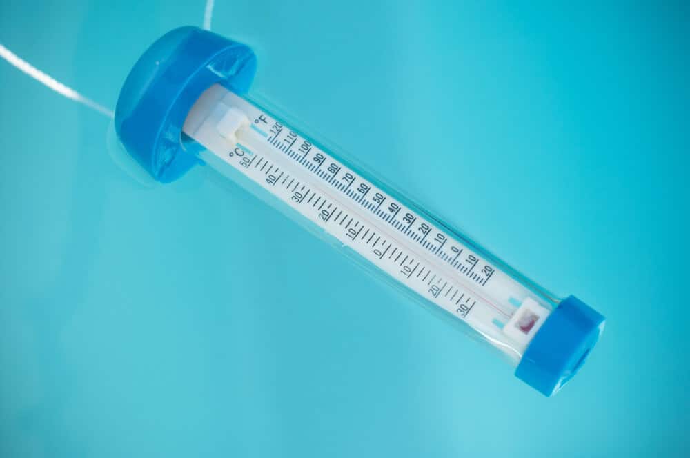 closeup of swimming pool thermometer floating on the water - Keeping Your Pool Temperature Level all Day